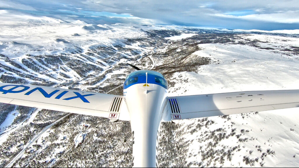 Flygplan som flyger över ett snötäckt fjällandskap